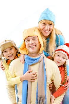 Two children and wife in winter clothes embracing a happy man