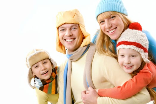 Two children and wife in winter clothes embracing a happy man on white background