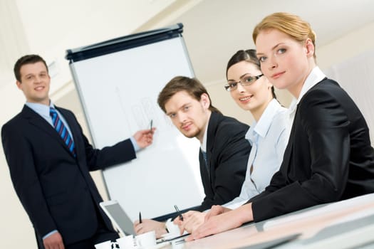 Portrait of smiling business partners looking at camera during meeting in office