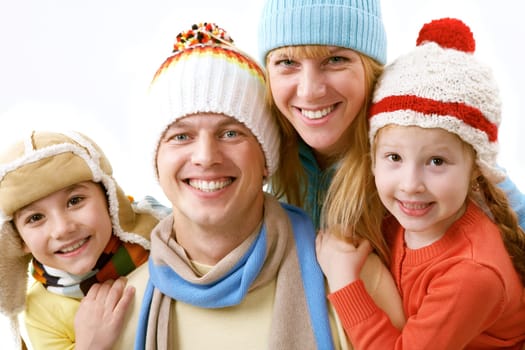A portrait of a happy family of four in winter clothing