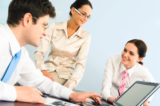 Business-team of three smiling people discussing new working ideas