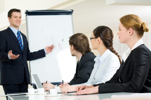 Photo of successful businessman sharing ideas by whiteboard with partners at presentation