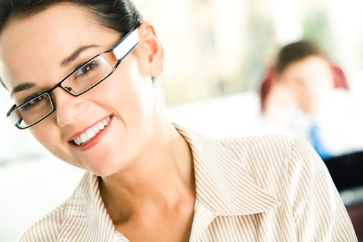 Portrait of happy female in glasses looking at camera with her head slightly aside