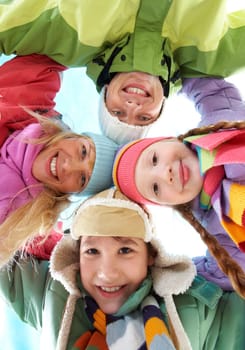 Below angle of happy family embracing and looking at camera