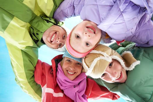 Below angle of happy family embracing and looking at camera