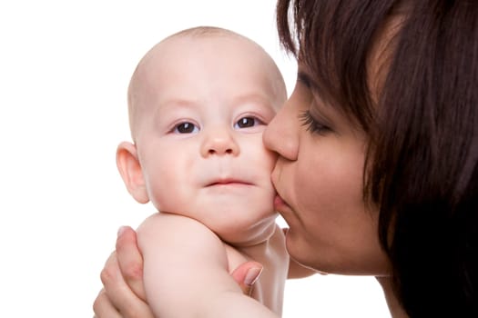 Close-up of careful mummy kissing her baby son on white background
