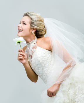 Profile of joyful bride with artificial flower looking straight and slightly upwards