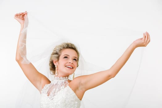 Portray of happy beautiful fiancee raising hands with veil