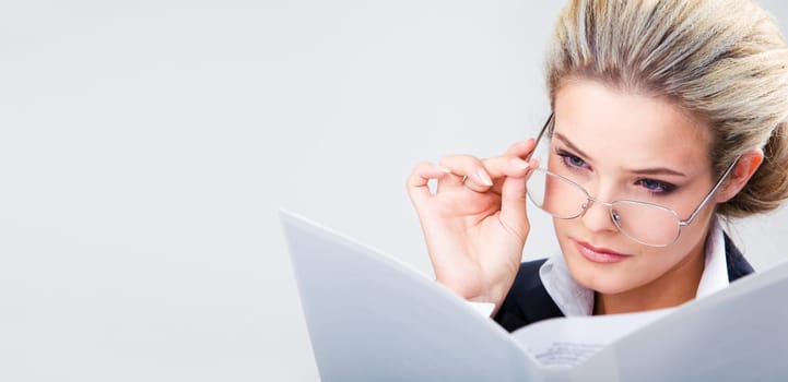 Photo of confident business lady wearing glasses and looking at plan seriously