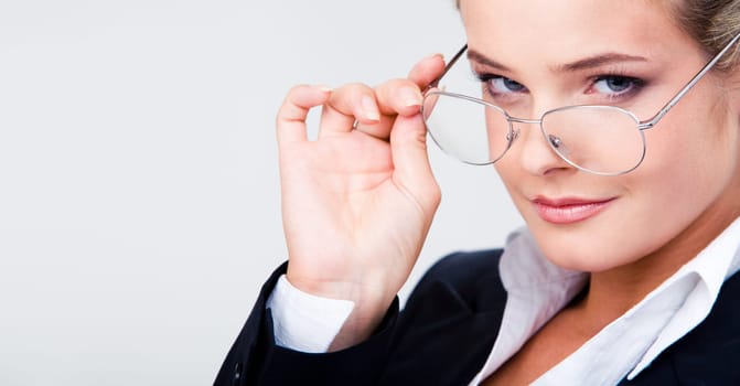 Close-up of elegant female touching her glasses while looking at camera