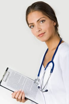 Portrait of pretty female assistant with clipboard in hand looking at camera over white background