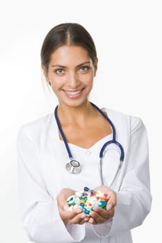 Portrait of happy pharmacist with handful of vitamins looking at camera with smile
