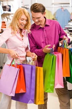 Image of woman showing to man what she bought in the shop