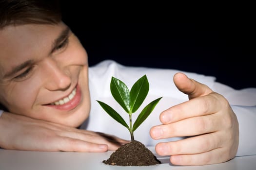 Image of man observing cultivation of a young plant