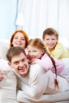 Portrait of happy parents and their children relaxing on the sofa at home
