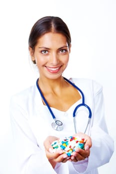 Portrait of happy pharmacist with handful of vitamins looking at camera