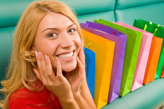 Portrait of woman being happy out of presents placed on sofa