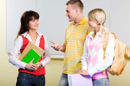 Photo of smart teenager standing and explaining something to serious girl in college