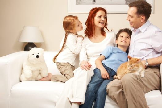 Friendly family members sitting on comfortable sofa and communicating at home