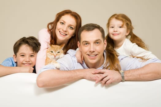 Happy couple and their two children smiling with pet among them