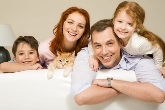 Portrait of siblings and their parents with cute cat looking at camera