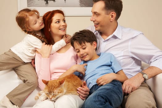 Portrait of affectionate parents and their children enjoying weekend day at home