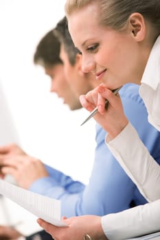 Successful businesswoman reading paper in working environment