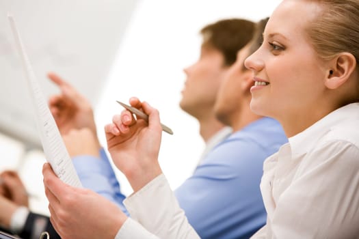 Successful businesswoman reading paper in working environment