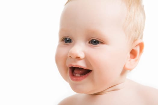 Close-up of happy blue-eyed baby smiling and looking aside