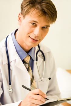 Portrait of confident male doctor ready to write something while looking at camera
