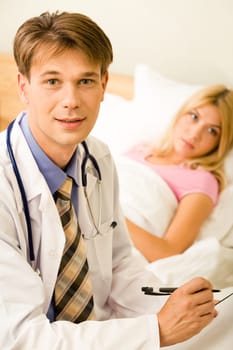 Portrait of handsome doctor looking at camera on background of his patient