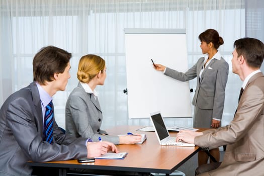 Photo of attentive business partners listening to smart teacher presenting new project
