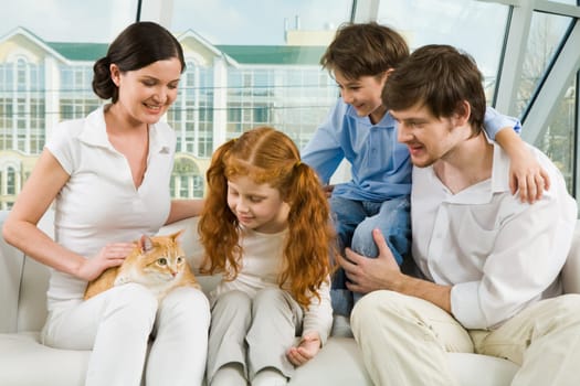 Portrait of young man and woman enjoying weekend day with their children and cute cat