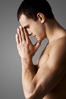 Image of calm guy keeping his palms by face