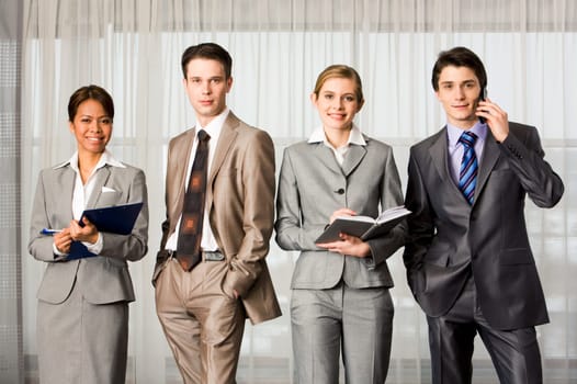 Elegant business people standing in line and looking at camera