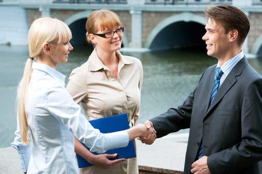Photo of happy partners expressing trust by handshake after concluding bargain