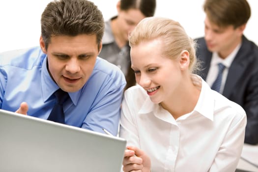 Business partners looking at laptop monitor in working environment