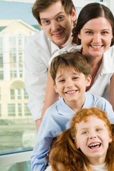 Faces of happy family members looking at camera and laughing