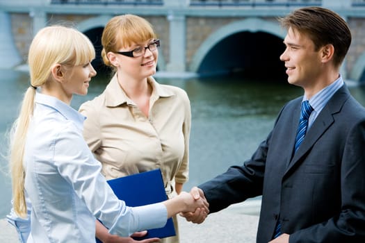 Photo of happy partners expressing trust by handshake after concluding bargain