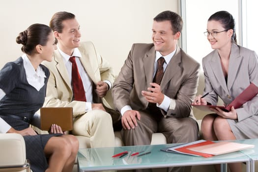 Portrait of business partners sitting on sofa and negotiating