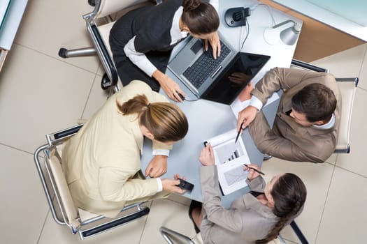 Above view of executive business group sitting at desk in office and busy working