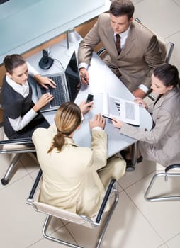 View from above of serious business group working at table in office