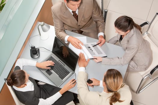Above view of executive business group sitting at desk in office and busy working