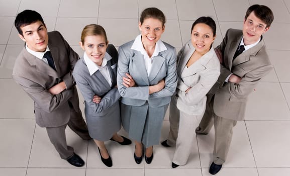 Portrait of confident business group standing on the floor and looking at camera with smiles