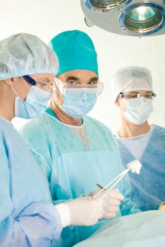 Image of elderly surgeon looking at camera during operation