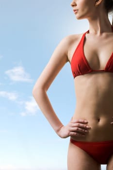 Image of luxurious woman in red bikini posing before camera at summer