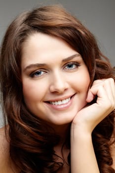 Portrait of charming girl touching her face and looking at camera