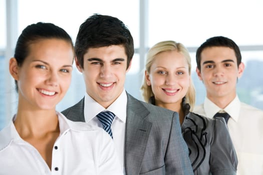 Handsome boss looking at camera with smile surrounded by employees