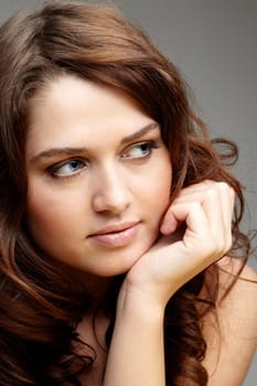 Portrait of charming girl touching her face and looking aside