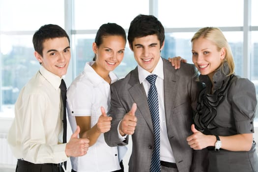 Portrait of happy business partners looking at camera with smiles and showing sign of okay